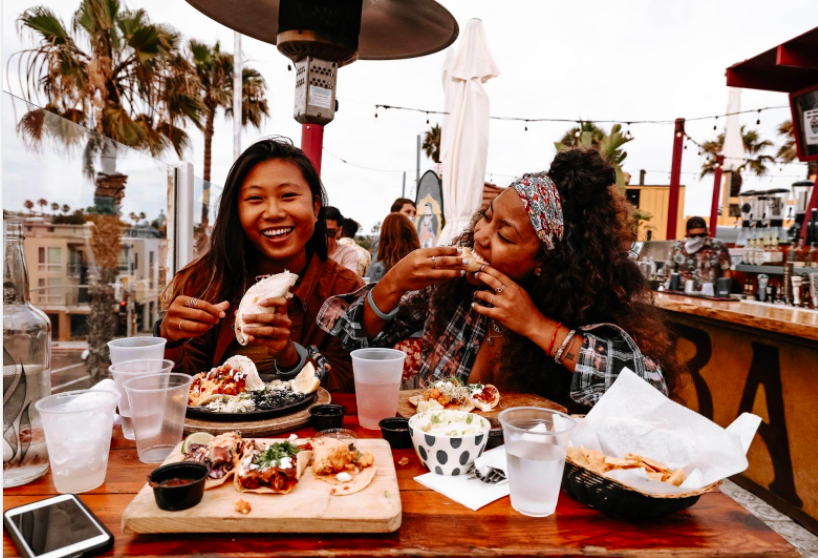 a group of people sitting at a table eating food