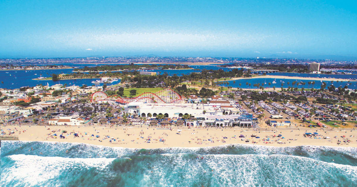 a crowded beach next to the ocean